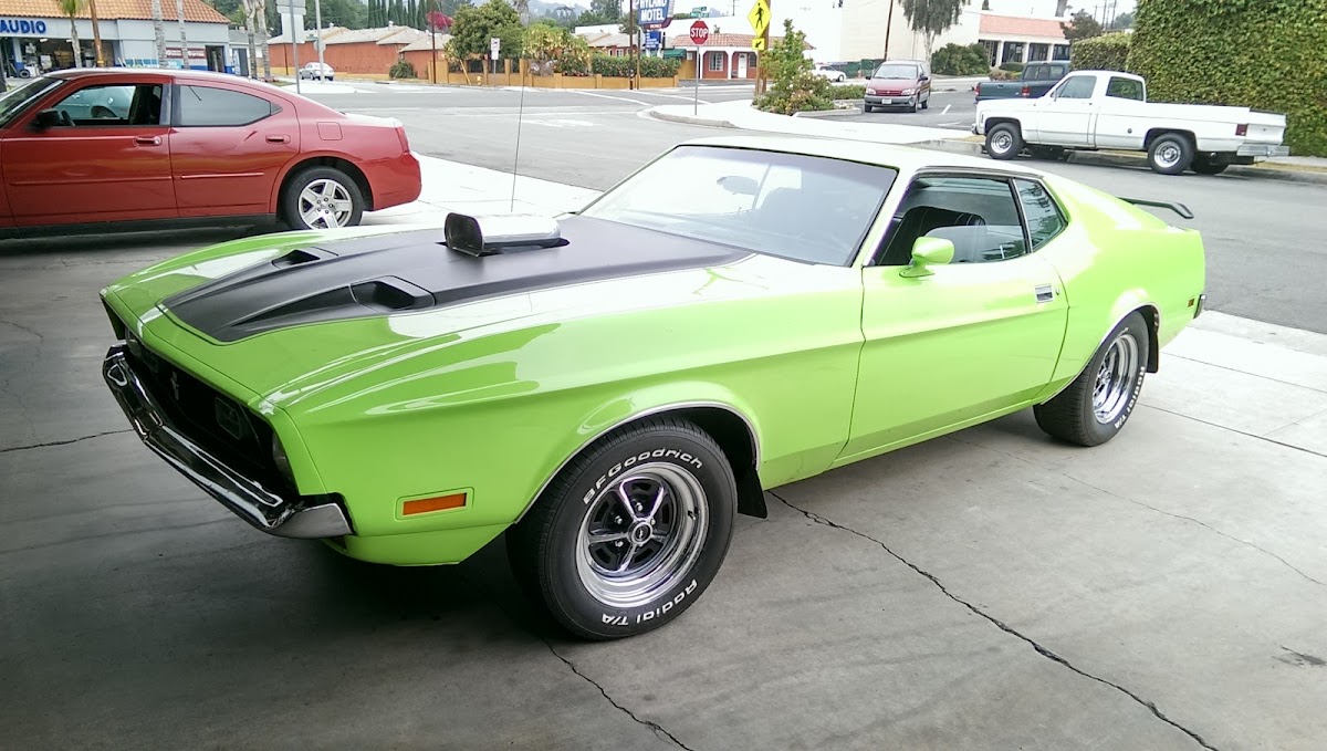 A lime green Ford Mustang Mach 1 parked on the forecourt at White Automotive