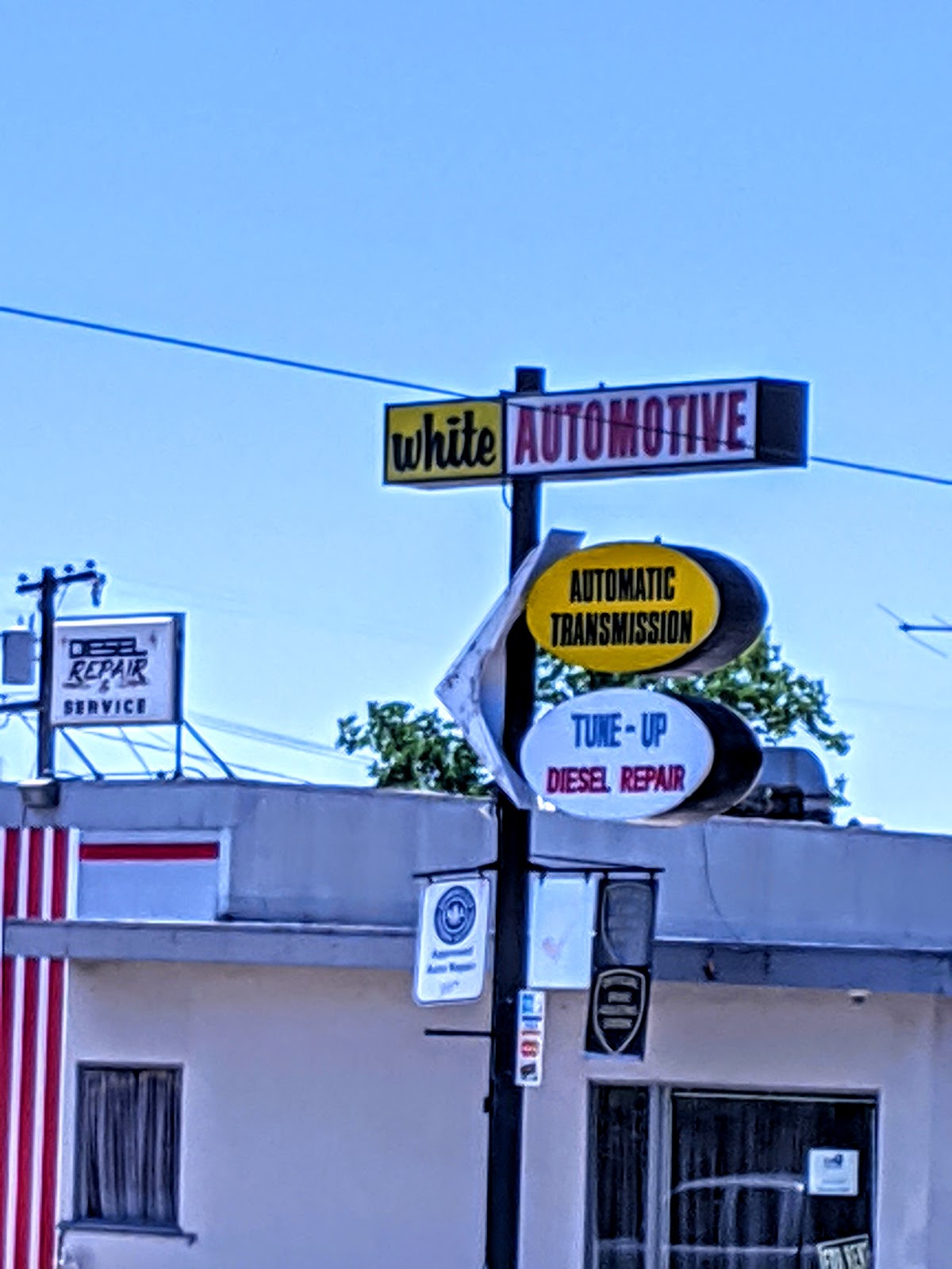 The White Automotive pole sign reading automatic transmission, tune up and diesel repair, with the AAA approved badge below